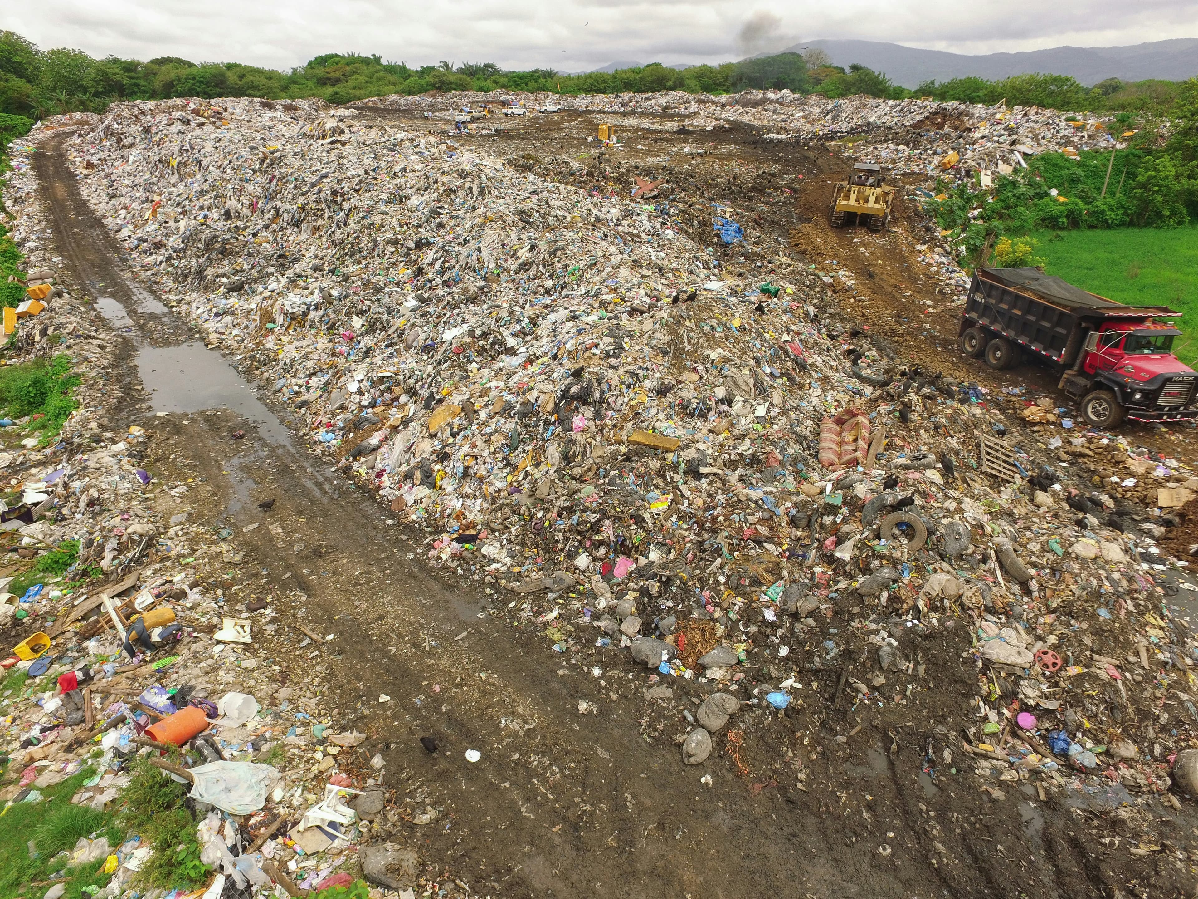 Illustrative elevated view of a dumpsite with waste and access tracks.